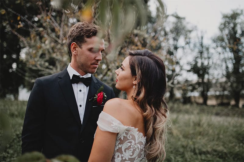 Testimonials | Vinka Design | Real Bridal Reviews from Our Clients | Amber and Rhys face to face with the off shoulder of the designer gown highlighted