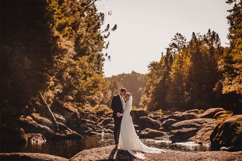 Testimonials | Vinka Design | Real Bridal Reviews from Our Clients | Jane and husband next to beautiful river and boulders