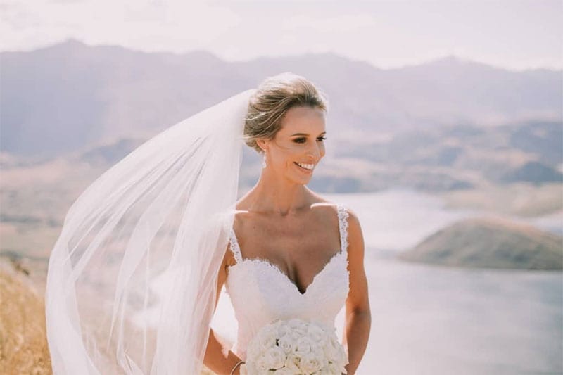 Testimonials | Vinka Design | Real Bridal Reviews from Our Clients | Julianne close up on hilltop in sunshine with stinning bespoke dress neckline highlighted