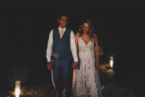 Testimonials | Vinka Design | Real Bridal Reviews from Our Clients | Megan and Tim in dark light with layers of bespoke gown highlighted