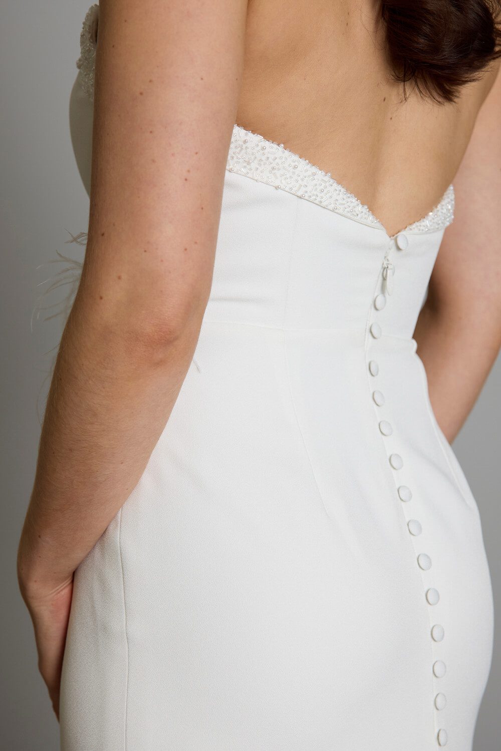 Hallie bridal crepe wedding gown with scoop neckline, seed pearl and bugle bead embellishment, crossover skirt and side split