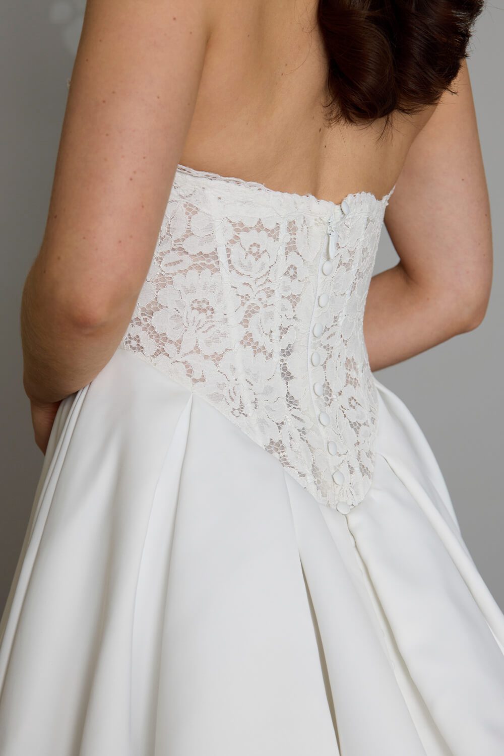 Indie strapless lace wedding dress with semi-sheer boned bodice, inverted pleated Duchesse satin skirt and button detailing down the back
