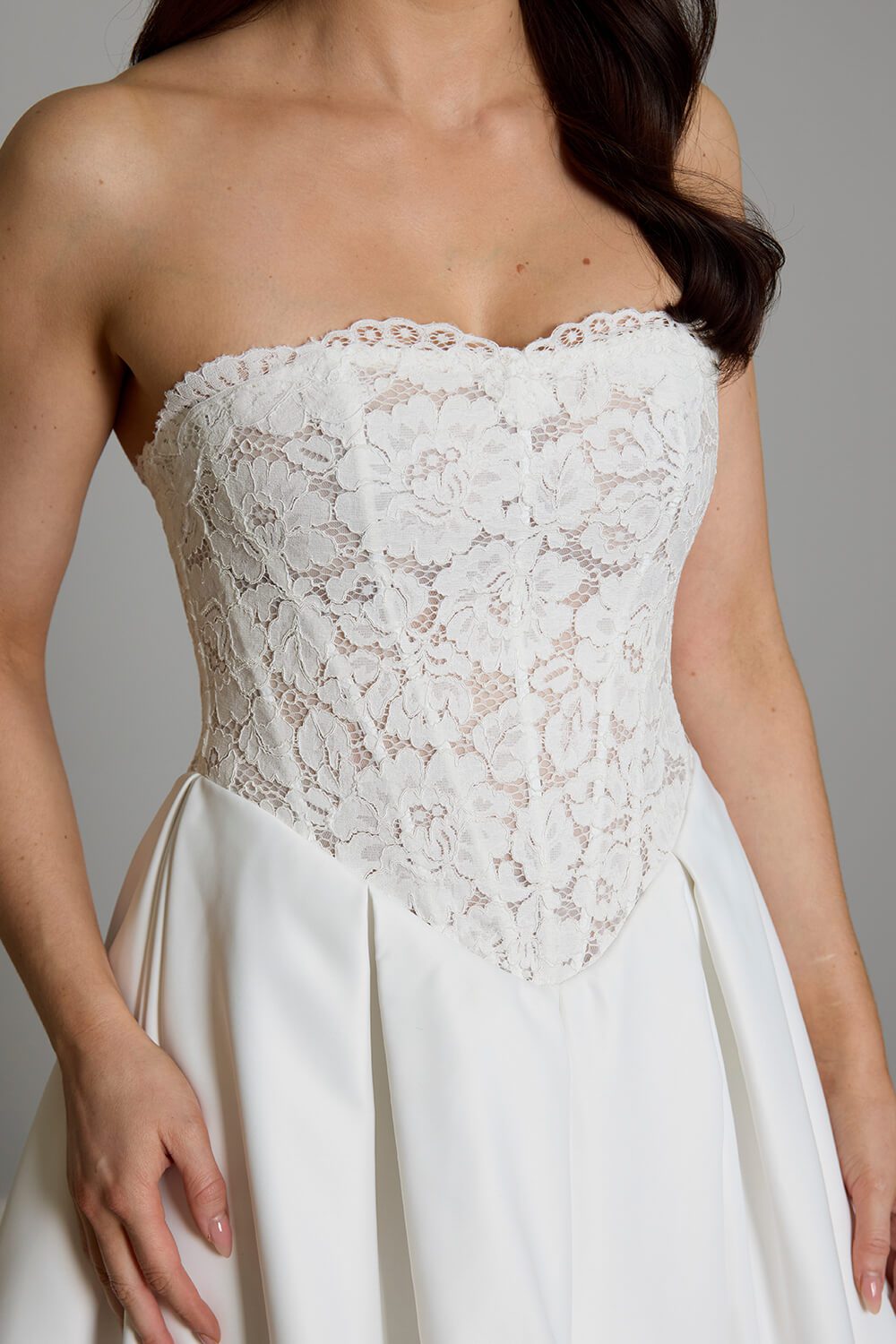 Indie strapless lace wedding dress with semi-sheer boned bodice, inverted pleated Duchesse satin skirt and button detailing down the back