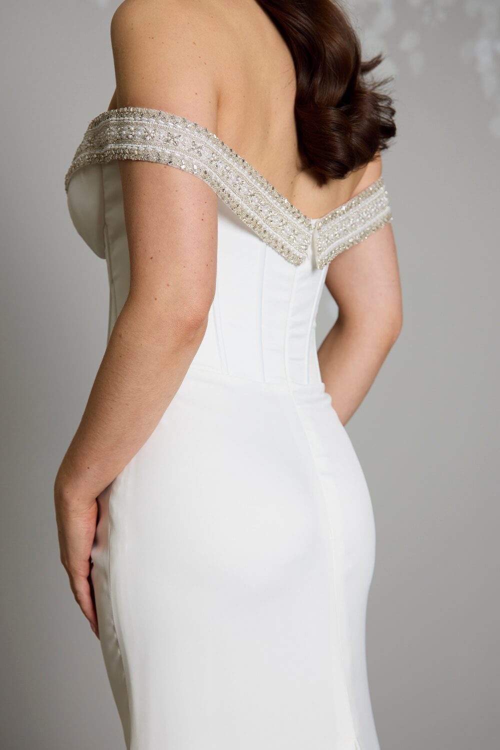Noa Toscano soft satin corset wedding gown with exposed boning, draped slim skirt and crystal embellished off-shoulder detail