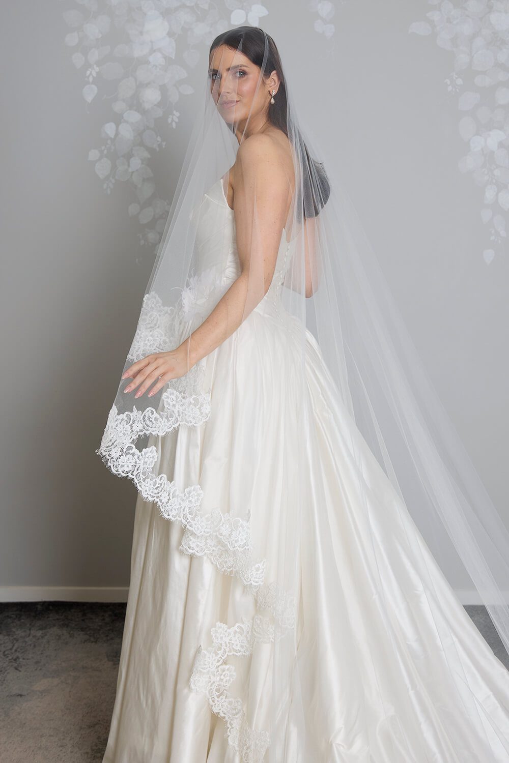 Margarita corded Chantilly lace mantilla veil with intricate lace edging framing the bride’s face and falling over her wedding gown.