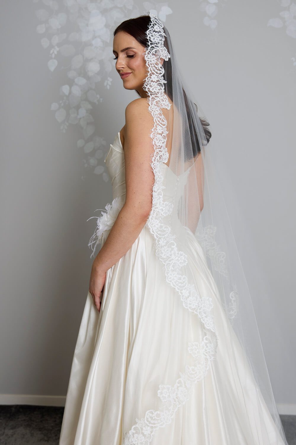 Margarita corded Chantilly lace mantilla veil with intricate lace edging framing the bride’s face and falling over her wedding gown.