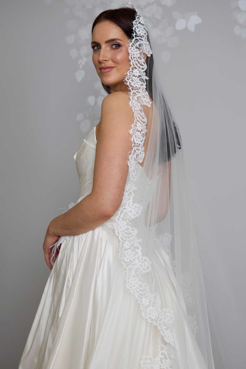 Margarita corded Chantilly lace mantilla veil with intricate lace edging framing the bride’s face and falling over her wedding gown.